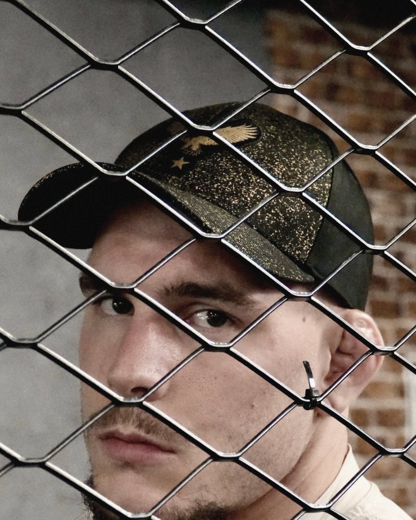 Théo Ulrich derrière le grillage, casquette YPSUM